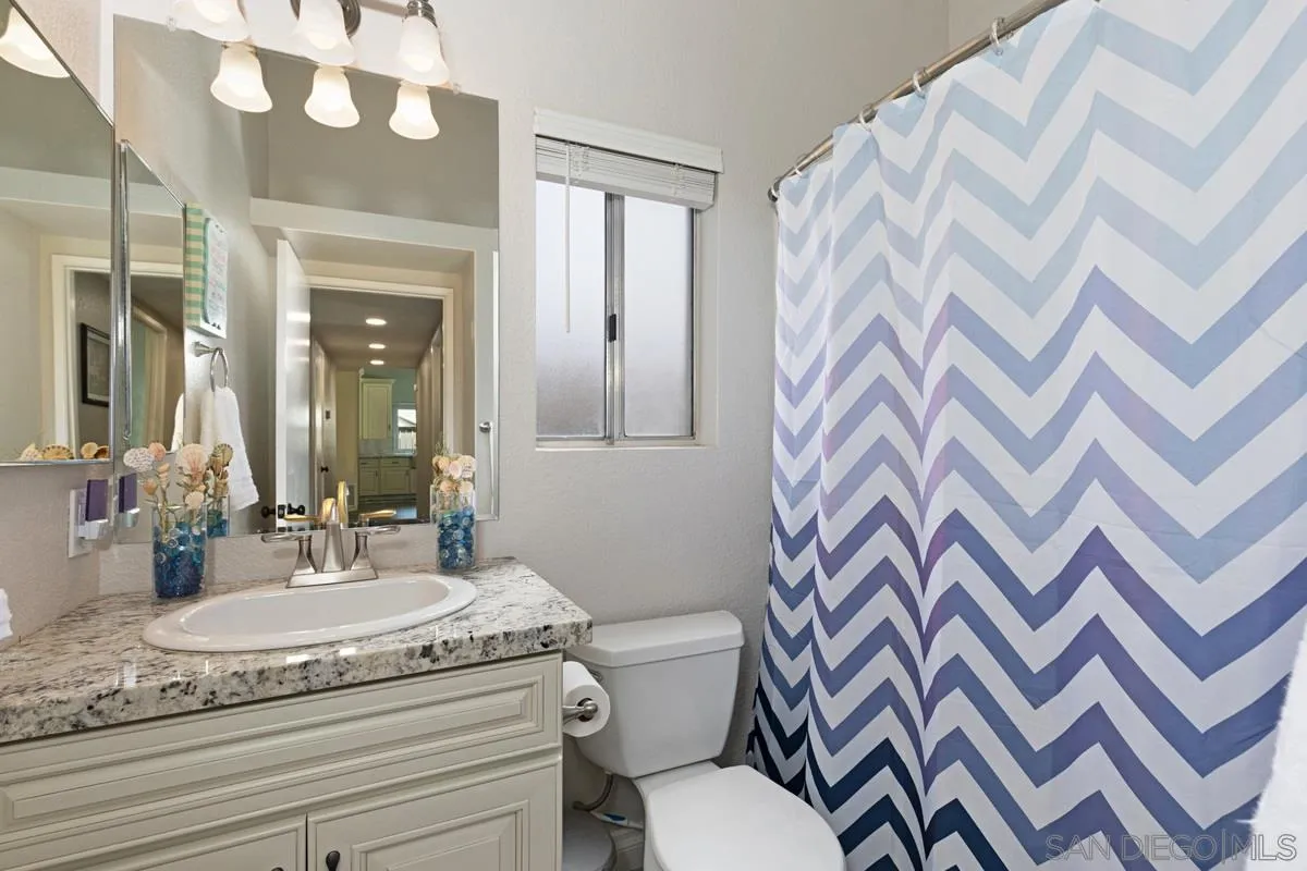 22895 Temet Street Wildomar, CA 92595 - Photo 22 of 36 a bathroom with a granite countertop sink mirror vanity and toilet