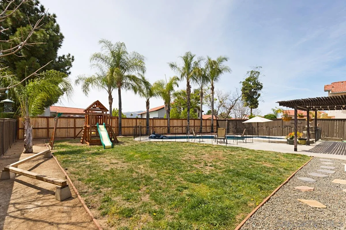 22895 Temet Street Wildomar, CA 92595 - Photo 30 of 36 a view of a swimming pool with a lawn chairs under palm trees
