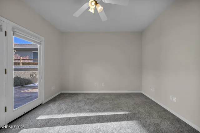 an empty room with a window and a ceiling fan