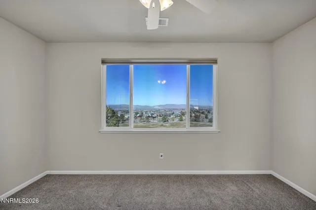 a large bed sitting in a bedroom next to a window and a chandelier