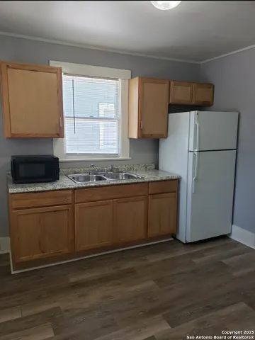 a kitchen with stainless steel appliances granite countertop a refrigerator a stove a sink and a microwave