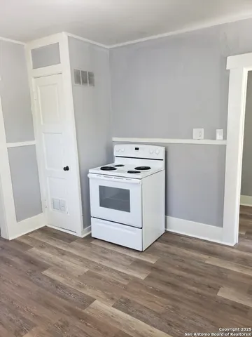 a white kitchen with wooden floor