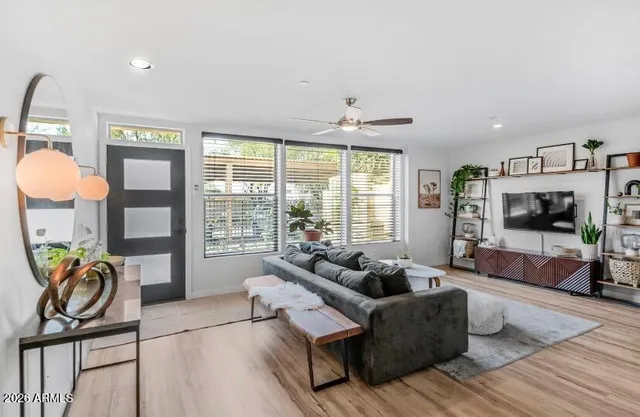 a living room with furniture a flat screen tv and a large window