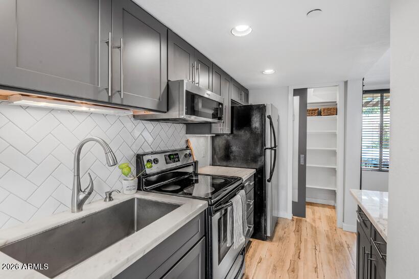 2929 North 39th Street, Unit 2 Phoenix, AZ 85018 - Photo 9 of 26 a kitchen with stainless steel appliances granite countertop a refrigerator a sink dishwasher a stove and a dining table with wooden floor