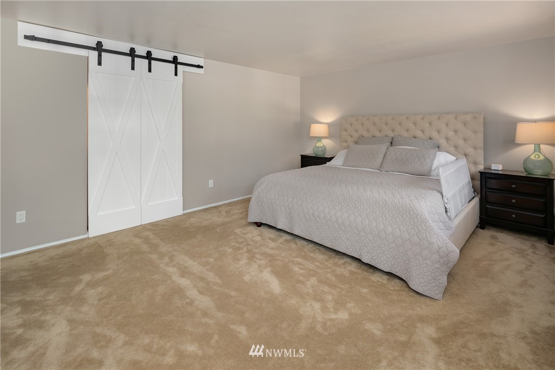 8 170th Place Southwest Bothell, WA 98012 - Photo 14 of 21 a large bed sitting in a bedroom next to a lamp