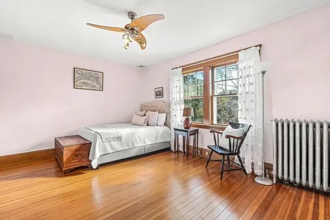 a bedroom with a bed and wooden floor