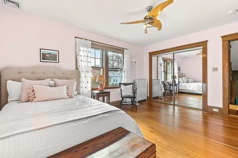 a bedroom with a large bed a chandelier and windows