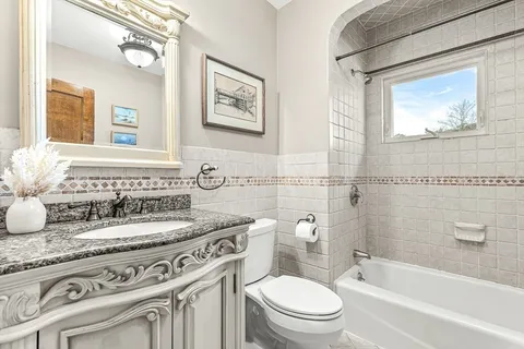 a bathroom with a granite countertop toilet a sink and a bathtub