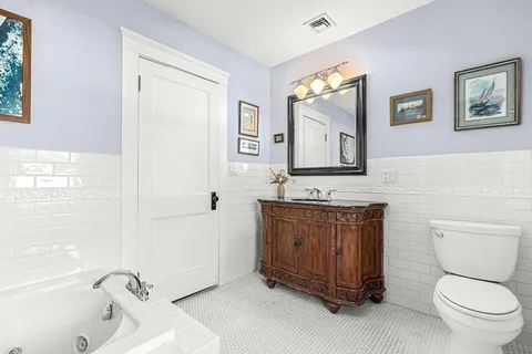 a bathroom with a toilet a sink and mirror