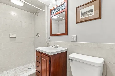 a bathroom with a toilet a sink and mirror