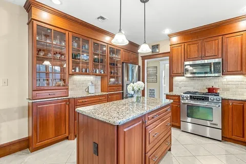 a kitchen with stainless steel appliances granite countertop a stove a sink and a refrigerator