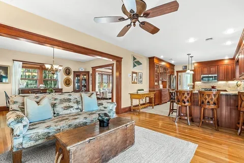 a living room with furniture kitchen view and a large window