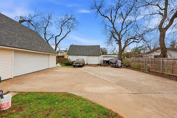 a front view of a house with a garden and tree