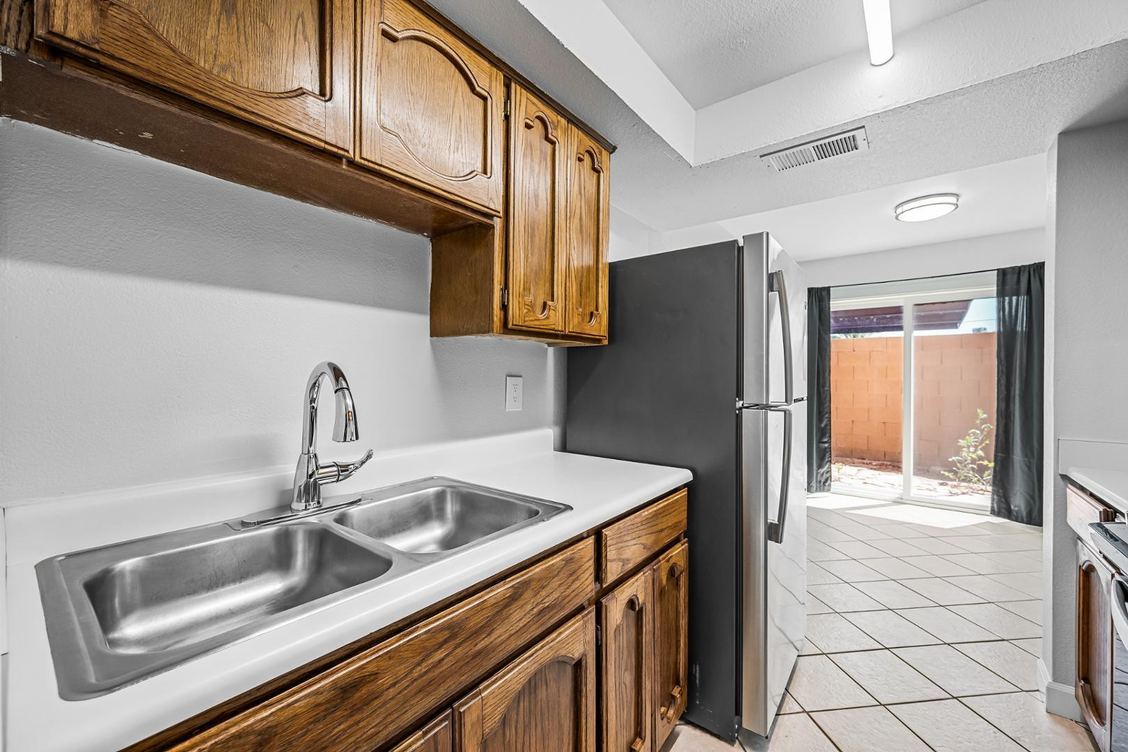 1455 North Alma School Road, Unit 11 Mesa, AZ 85201 - Photo 3 of 17 a kitchen with a sink a refrigerator and a sink