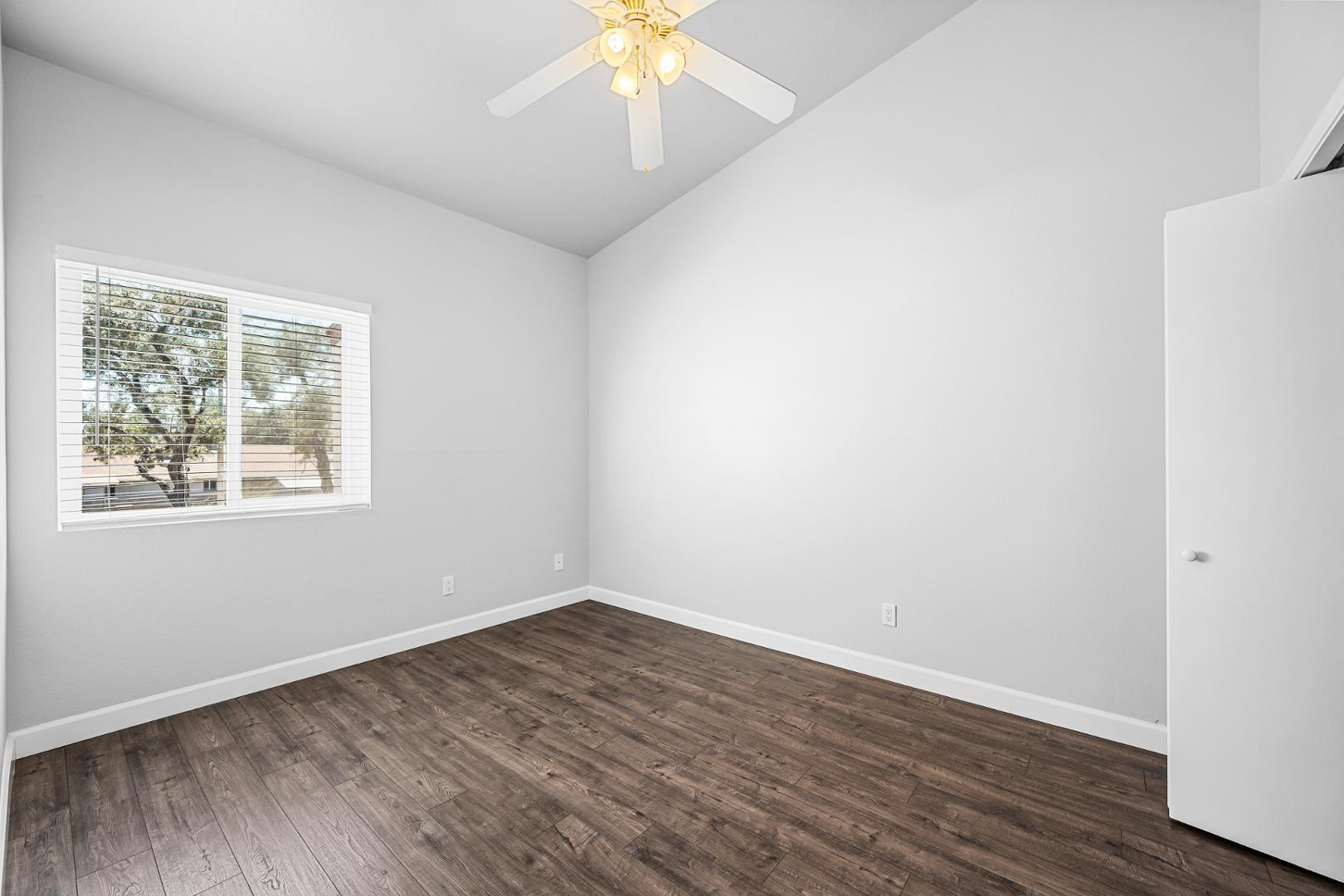 1455 North Alma School Road, Unit 11 Mesa, AZ 85201 - Photo 6 of 17 an empty room with wooden floor and windows