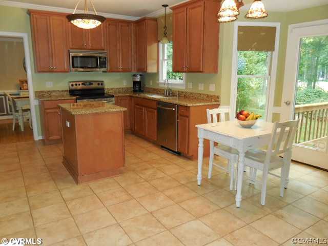 13904 Sagebrook Road Midlothian, VA 23112 - Photo 4 of 19 a kitchen with stainless steel appliances granite countertop a stove a sink a microwave and a refrigerator