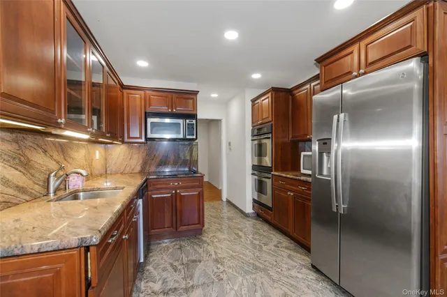 a kitchen with stainless steel appliances granite countertop a refrigerator and a sink