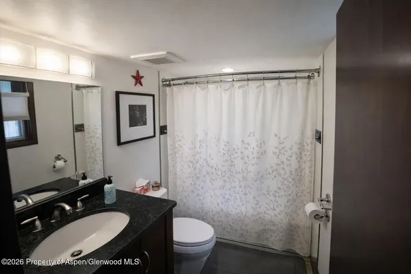 a bathroom with a sink toilet and a mirror