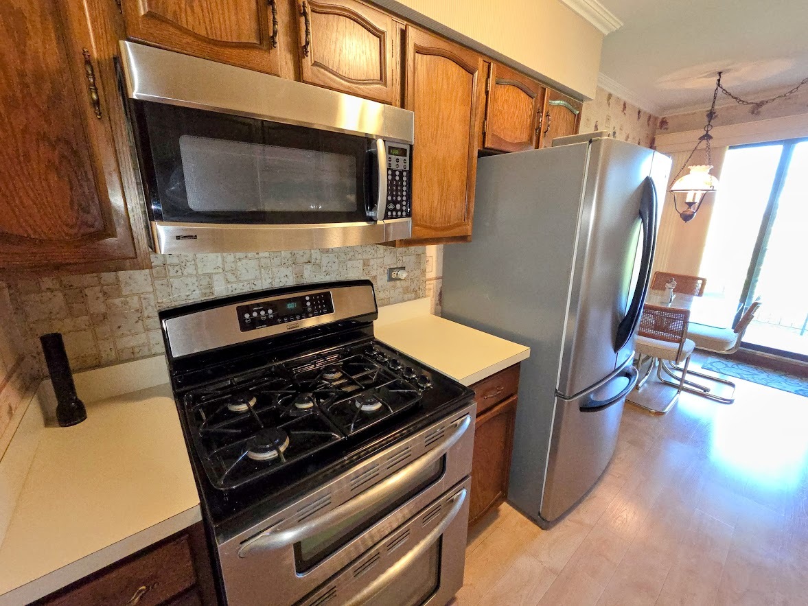 1-s150 Spring Road, Unit 5B Oak Brook, IL 60181 - Photo 8 of 14 a kitchen with a stove and a microwave