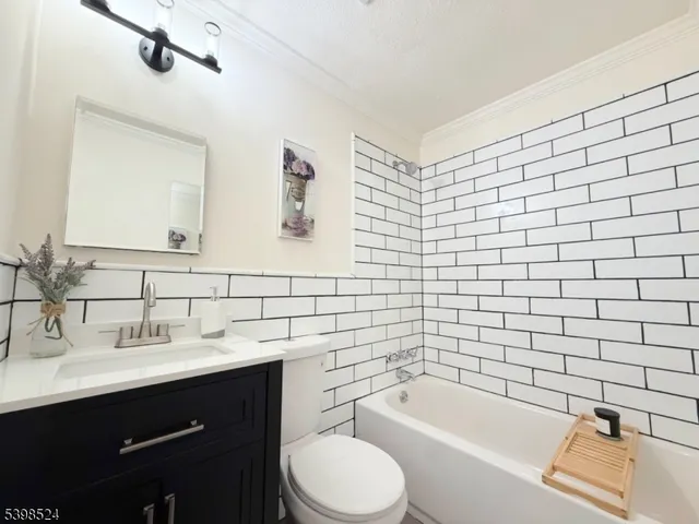 a bathroom with a bathtub sink vanity mirror and toilet