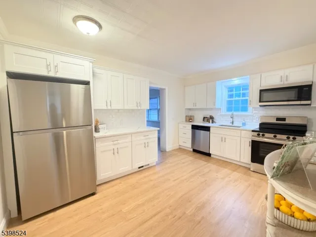 a kitchen with white cabinets and stainless steel appliances