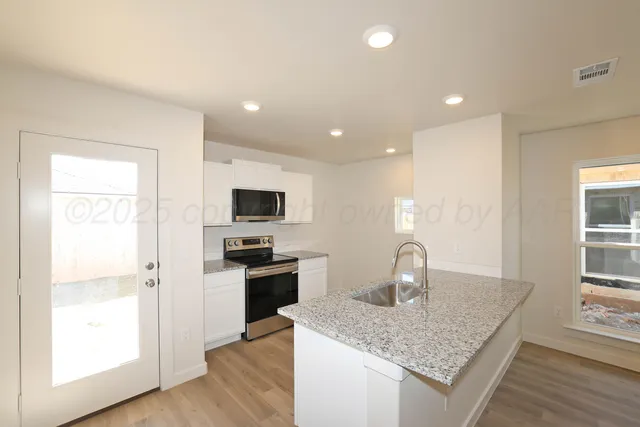 a kitchen with stainless steel appliances granite countertop a sink stove and refrigerator