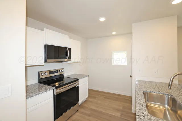 a kitchen with stainless steel appliances granite countertop a sink and a microwave