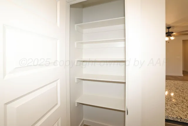 a view of walk in closet with empty racks