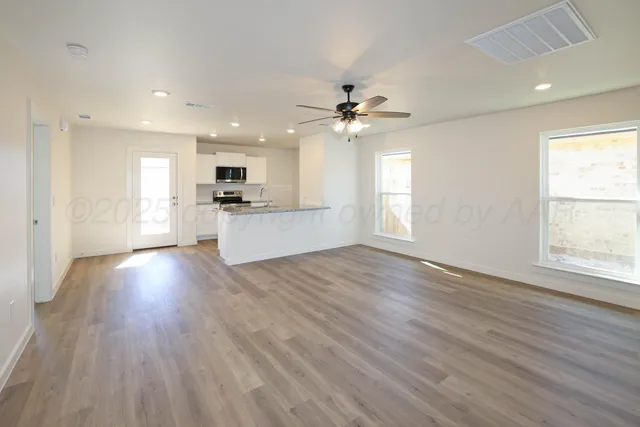 a view of an empty room and window with wooden floor