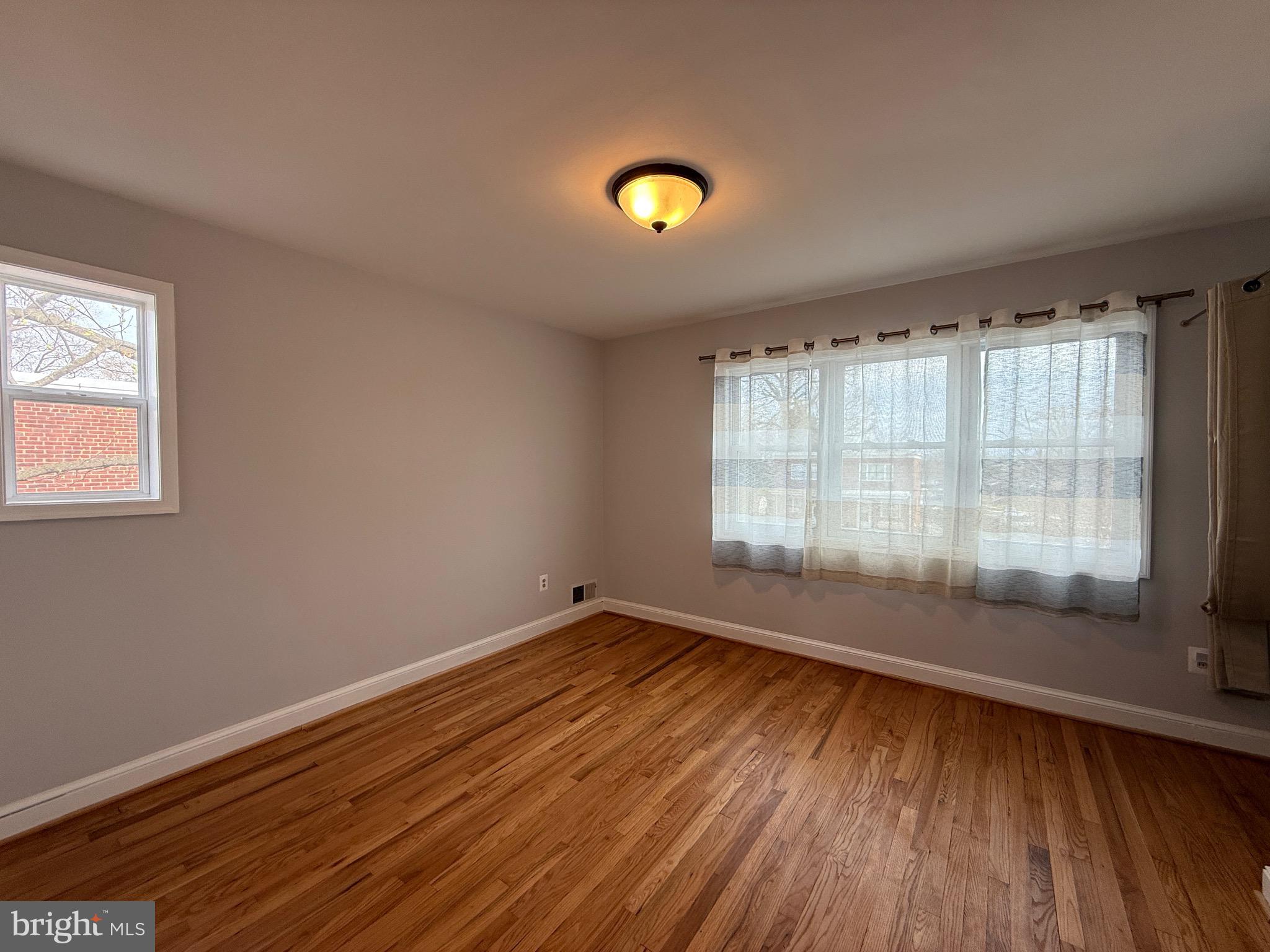 8518 11th Avenue Silver Spring, MD 20903 - Photo 7 of 13 a view of an empty room with wooden floor and a window