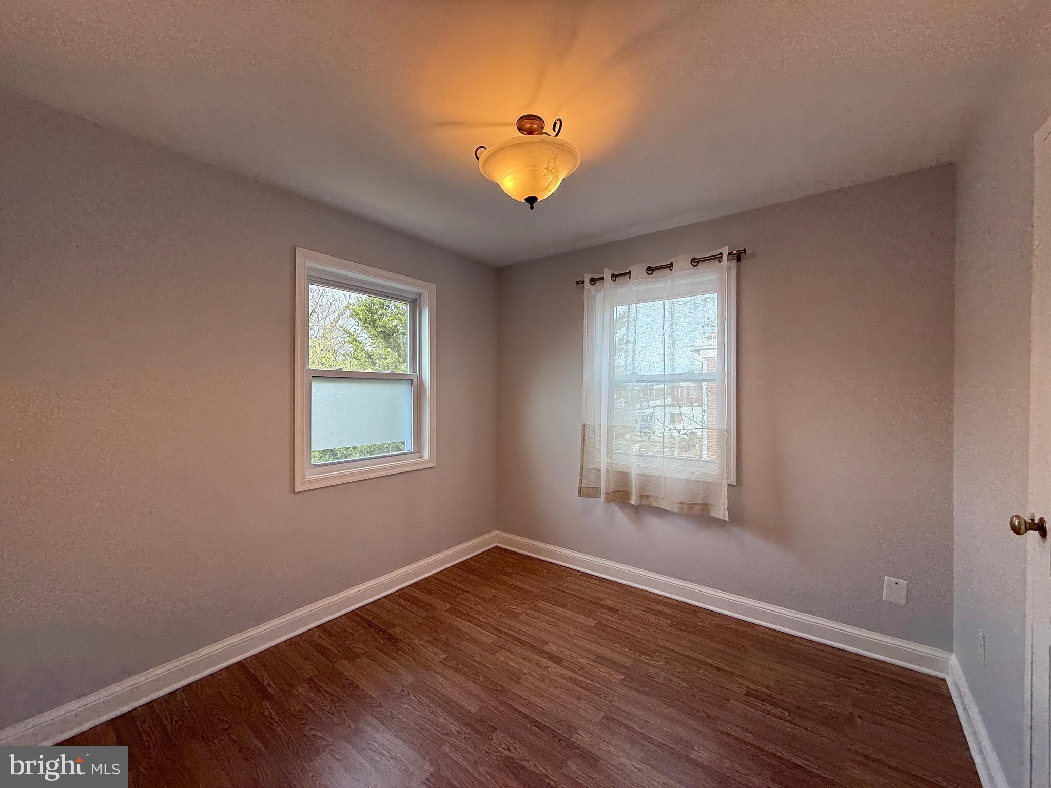 8518 11th Avenue Silver Spring, MD 20903 - Photo 9 of 13 a view of an empty room with wooden floor and a window