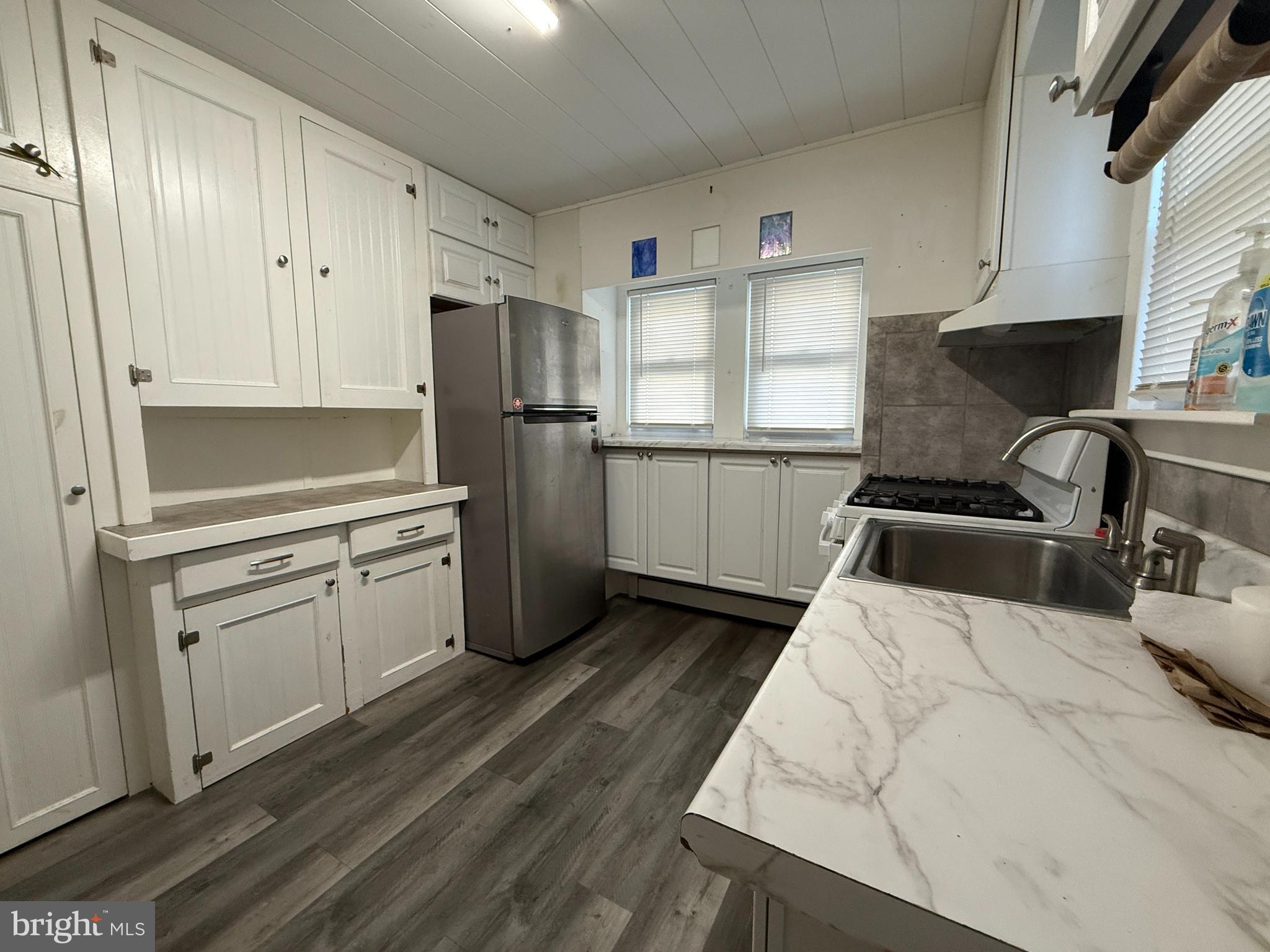 930 Tappan Street Forked River, NJ 08731 - Photo 7 of 13 a kitchen with a refrigerator sink and white cabinets