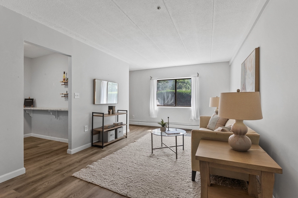 157 Franklin Street, Unit A10 Stoneham, MA 02180 - Photo 1 of 10 a living room with furniture and a wooden floor