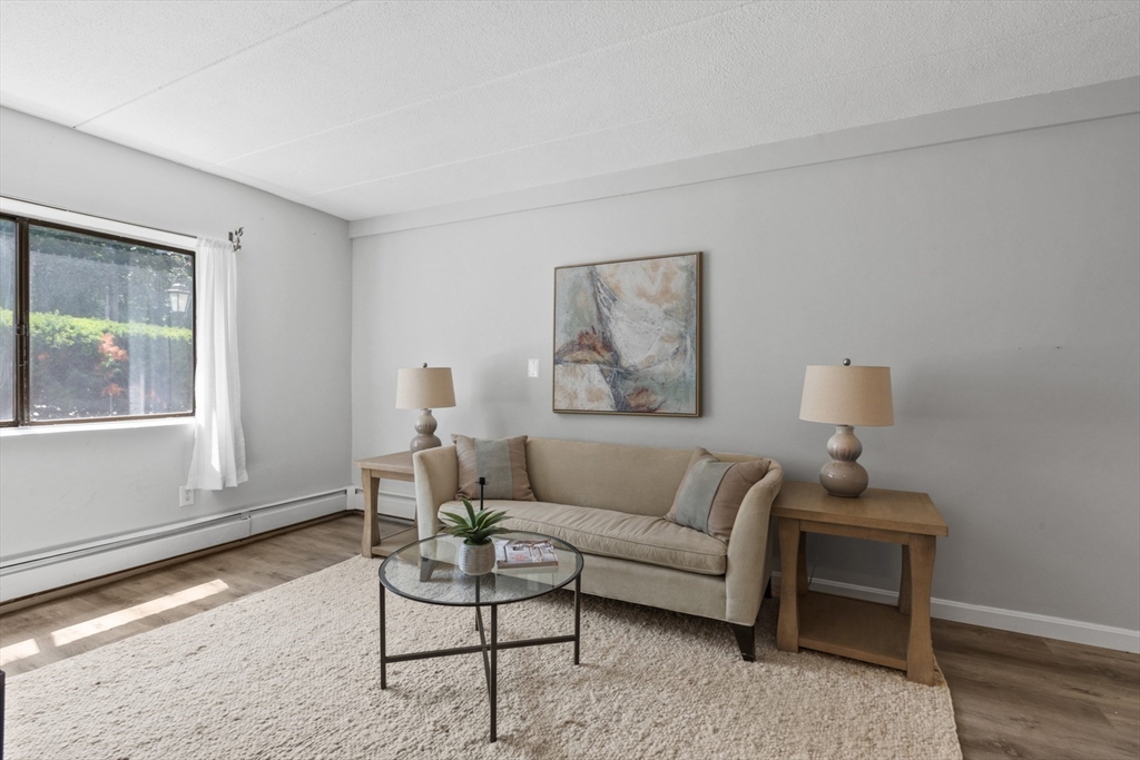 157 Franklin Street, Unit A10 Stoneham, MA 02180 - Photo 2 of 10 a living room with furniture and a window