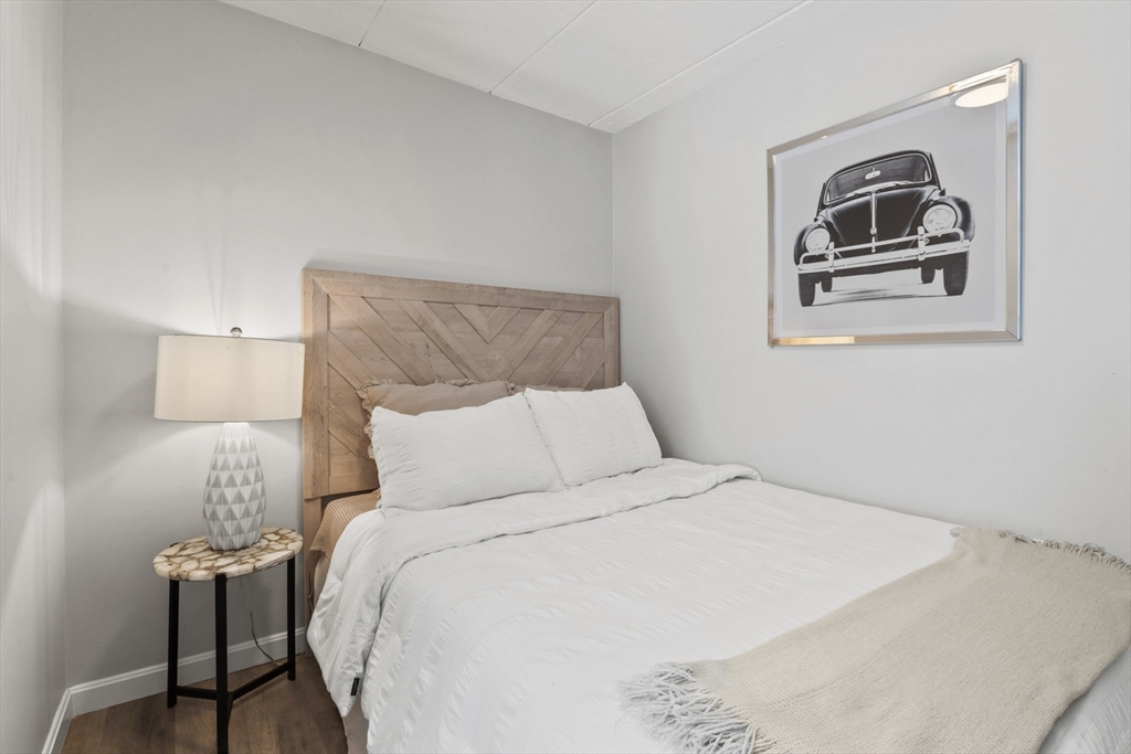 157 Franklin Street, Unit A10 Stoneham, MA 02180 - Photo 4 of 10 a bedroom with a bed and a painting on the wall