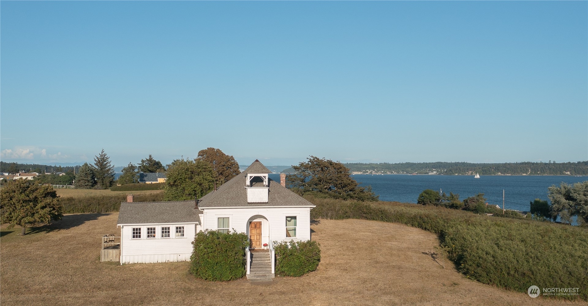 a view of a house with a yard and a large parking space