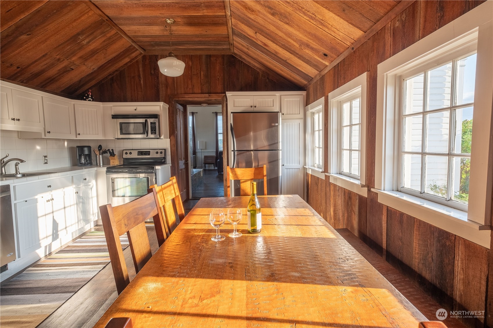 650 Zylstra Road Coupeville, WA 98239 - Photo 14 of 26 a view of a kitchen with kitchen island a large window cabinets a sink and stainless steel appliances