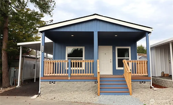 a front view of a house with porch and wooden fence