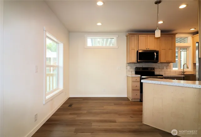 a kitchen with stainless steel appliances granite countertop a stove a sink and a microwave