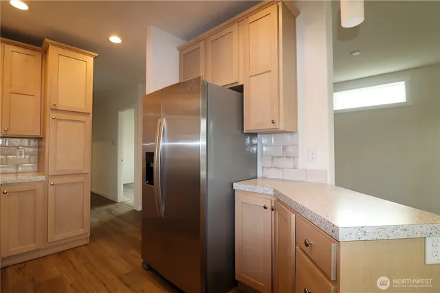 a kitchen with a refrigerator sink and cabinets