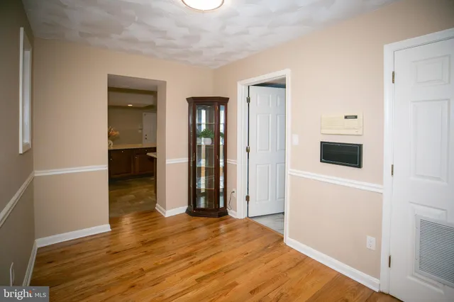 a view of a livingroom with wooden floor and a kitchen space