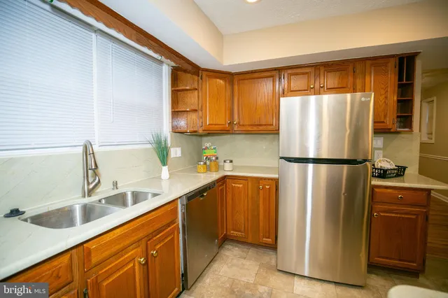 a kitchen with stainless steel appliances granite countertop a refrigerator and a sink