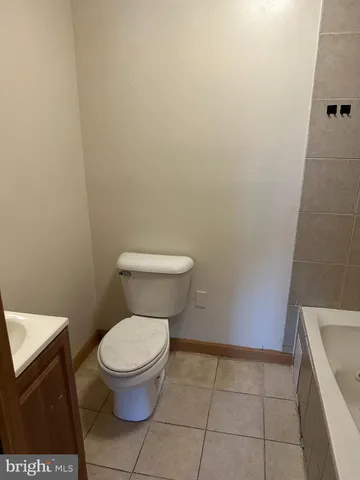a white toilet sitting next to a shower