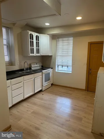 a kitchen with granite countertop a sink and a stove top oven