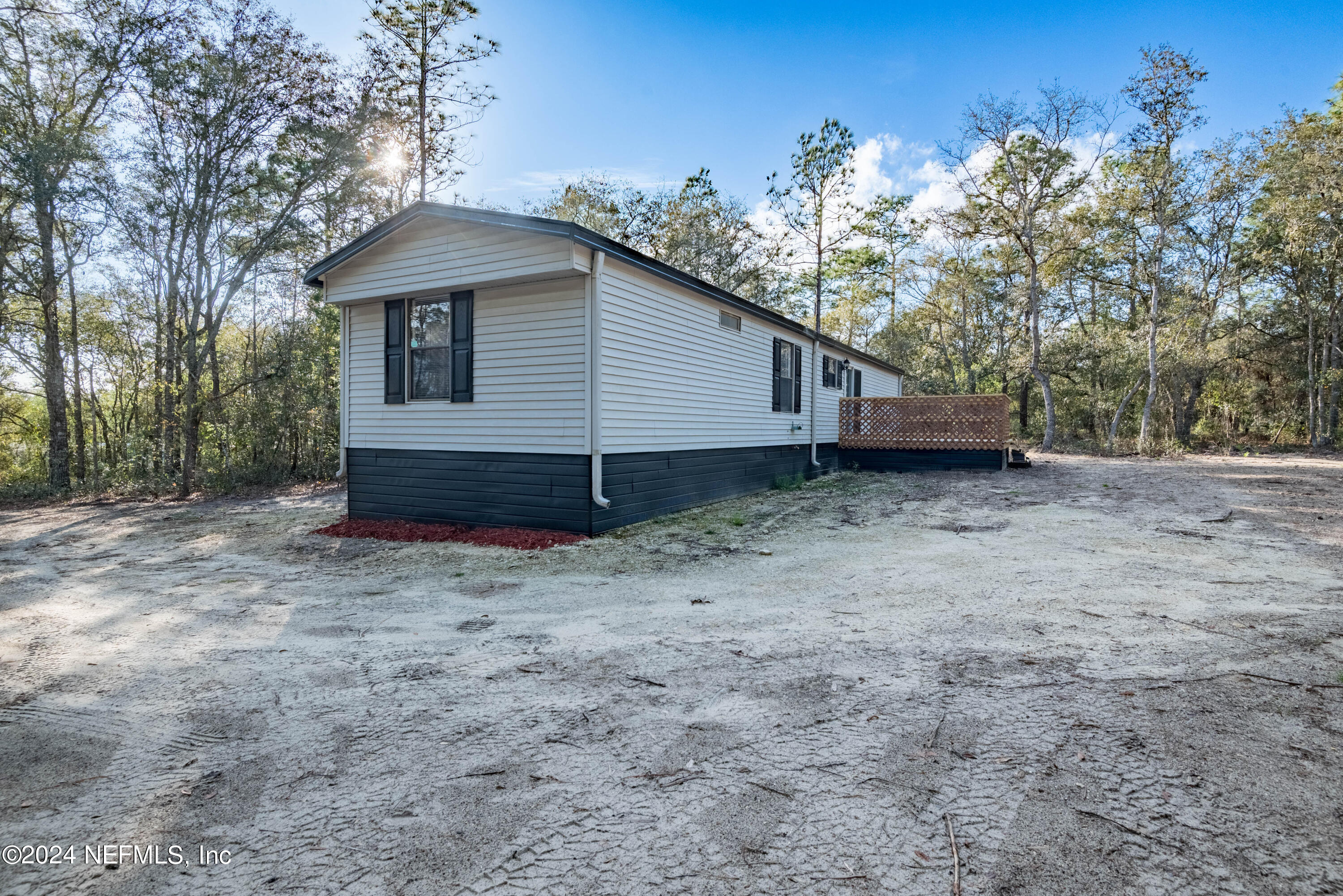 6787 Deer Springs Road Keystone Heights, FL 32656 - Photo 7 of 54 a house with trees in the background