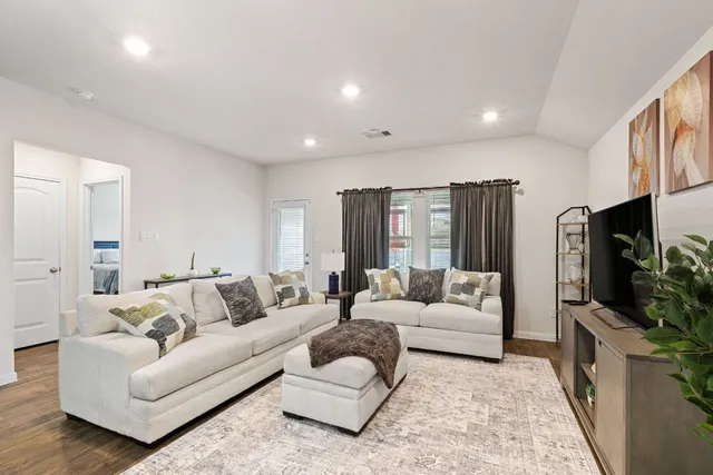 a living room with furniture a flat screen tv and a couch