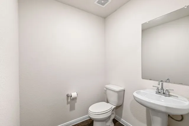 a bathroom with a sink a toilet and a mirror