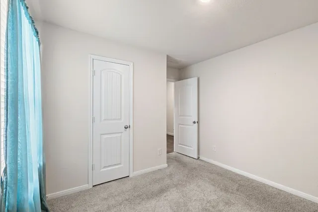 an empty room with windows and closet