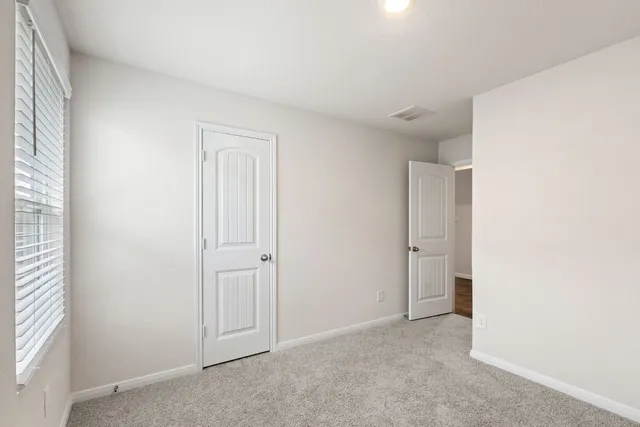 an empty room with windows and closet