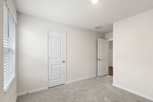 a bedroom with a bed lamp and a large window
